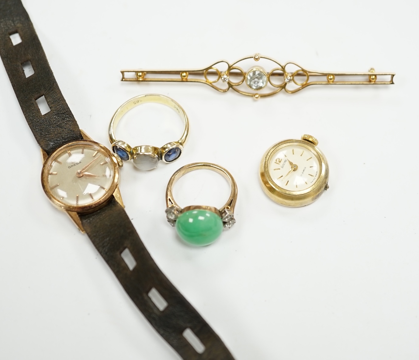 An Edwardian 15ct, aquamarine and diamond set three stone bar brooch, 74mm, a lady's yellow metal Omega manual wind wrist watch, a lady's rolled gold wrist watch a 14k and three stone sapphire ring the central stone a wh